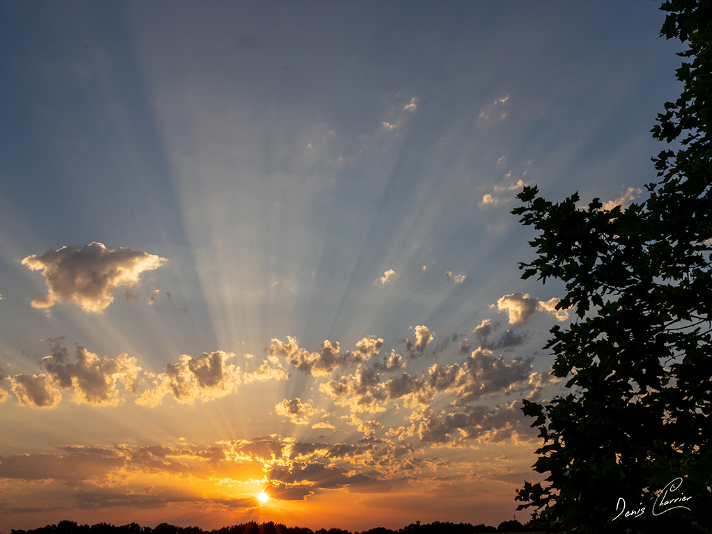 Levé du soleil dessinant ses rayons à travers les nuages