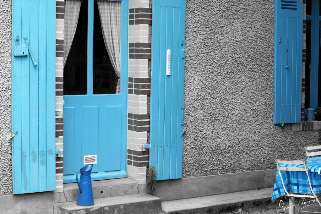 Porte d'entrée d'une maison bleu et broc bleu