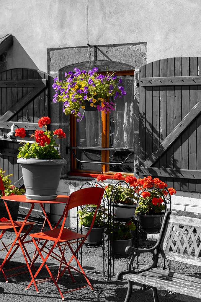 Mobilier de jardin extérieur devant une maison auvergnate typique aux volets rouge de Besse et Saint Anastaise