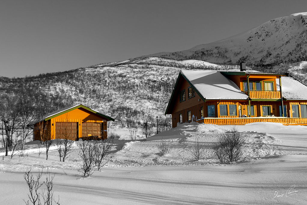 Maison peinte en jaune en Norvège l'hiver
